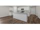 Bright kitchen features an island with granite countertops, modern appliances, and wood-look flooring at 57 Cape Point Dr., Conway, SC 29527