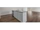 Close up view of kitchen island with granite countertop, stainless steel sink, and wood-look flooring at 57 Cape Point Dr., Conway, SC 29527