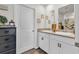 Bathroom featuring a double vanity with mirrors, white cabinets, modern fixtures, and decorative framed pictures at 589 Talisman Trail, Longs, SC 29568
