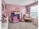 Charming pink bedroom filled with toys, a comfortable chair, and bright natural light at 589 Talisman Trail, Longs, SC 29568