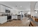 Bright kitchen features white cabinets, stainless steel appliances, and an open layout to the living area at 589 Talisman Trail, Longs, SC 29568