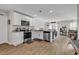 Open kitchen layout with white cabinets, stainless steel appliances, and wood flooring at 589 Talisman Trail, Longs, SC 29568
