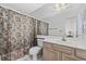 Bathroom with floral shower curtain, wood vanity, and mirror at 611 S 13Th Ave. # 175, Surfside Beach, SC 29575