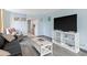 Living room with gray floors, black couch, and white TV stand at 7000 N Ocean Blvd. # 326, Myrtle Beach, SC 29572