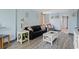 Living room with gray floors, black couch, and white TV stand at 7000 N Ocean Blvd. # 326, Myrtle Beach, SC 29572