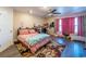 Bedroom boasts a ceiling fan and is adorned with a colorful rug, pink drapes, and comfy plush toys at 801 Benchmade Rd., Conway, SC 29527