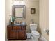 Half bathroom with dark wood vanity, tan walls, and framed mirror at 9547 Edgerton Dr. # 606, Myrtle Beach, SC 29572
