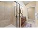 Bathroom featuring a glass shower, dark wood vanity, and tan tile at 9547 Edgerton Dr. # 606, Myrtle Beach, SC 29572