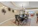 Well-lit dining room showcases an elegant chandelier and an ornamental table with surrounding palm decorations at 9547 Edgerton Dr. # 606, Myrtle Beach, SC 29572