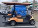 Orange four-passenger golf cart with tan seats at 9764 Leyland Dr. # 7, Myrtle Beach, SC 29572