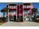 Red two-story house with parking and palm trees at 118 Seabreeze Dr., Murrells Inlet, SC 29576