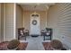 Charming front porch adorned with benches, decorative pillows, and potted plants, creating a cozy entry at 1501 Brighton Ln., Longs, SC 29568