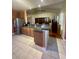 Modern kitchen with a large island bar, stainless steel appliances, open view to the living room, and tile flooring at 1501 Brighton Ln., Longs, SC 29568