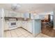 White kitchen features appliances and view to living room at 205 74Th Ave. N # 1603, Myrtle Beach, SC 29572
