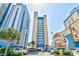 Lovely exterior of a beachfront building with a view of multiple parking spots, palm trees, and The Breakers Resort signage at 2106 N Ocean Bl N Ocean Blvd. # 211, Myrtle Beach, SC 29577