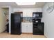 Small condo kitchen with black appliances and white cabinets at 2311 South Ocean Blvd. # 371, Myrtle Beach, SC 29577