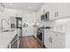 Modern kitchen with white cabinets, stainless steel appliances, and marble countertops at 244 Gloucester Way, Little River, SC 29566