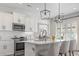 Modern kitchen with white cabinets, stainless steel appliances, and a large island at 244 Gloucester Way, Little River, SC 29566
