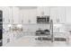 Modern kitchen with white cabinets, stainless steel appliances and marble countertops at 244 Gloucester Way, Little River, SC 29566