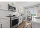 Modern white kitchen with stainless steel appliances and breakfast area at 244 Gloucester Way, Little River, SC 29566