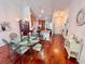 Dining area with glass table and wood floors flows into kitchen and entry at 344 Tall Palms Way, Little River, SC 29566