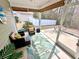 Inviting screened-in porch features comfortable wicker seating and serene backyard views at 344 Tall Palms Way, Little River, SC 29566