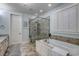 Spa-like bathroom with soaking tub, glass shower, and neutral tile at 404 Banyan Place, North Myrtle Beach, SC 29582