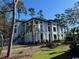 Elegant white home featuring a two-car garage, lush landscaping, and a charming staircase entry at 429 Harbour View Dr., Myrtle Beach, SC 29579
