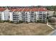 Exterior view of a multi-story condo building with balconies and well-maintained landscaping at 4390 Bimini Ct. # 206-C, Little River, SC 29566