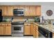 Well-lit kitchen with stainless steel appliances, wooden cabinets, and granite countertops to create a functional cooking space at 4390 Bimini Ct. # 206-C, Little River, SC 29566