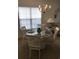 Dining room with glass table, chandelier, and large window with blinds at 5011 Harvest Dr. # 101, Myrtle Beach, SC 29579