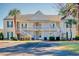 Inviting condo building with a charming white exterior and manicured landscaping and plentiful parking at 5011 Harvest Dr. # 101, Myrtle Beach, SC 29579