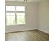 Bedroom featuring a large window with wooded views and wood-look floors at 81 Delray Dr. # 2-C, Murrells Inlet, SC 29576