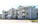Multi-unit building, light green siding, white trim, balconies, and palm trees at 81 Delray Dr. # 2-C, Murrells Inlet, SC 29576