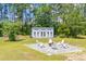 Picturesque backyard with firepit and chairs surrounded by lush greenery at 899 Kinlaw Ln., Conway, SC 29527