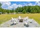 Spacious backyard with Adirondack chairs around a firepit and a tranquil pond view at 899 Kinlaw Ln., Conway, SC 29527