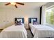 Bright bedroom features twin beds with blue accents, a ceiling fan, and a window overlooking the outdoors at 899 Kinlaw Ln., Conway, SC 29527