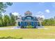 Beautiful blue home featuring a striking exterior with multiple levels, complemented by lush green lawns at 899 Kinlaw Ln., Conway, SC 29527