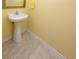 Powder room with pedestal sink, tiled floors and yellow walls at 114-A 11Th Ave. S, Surfside Beach, SC 29575