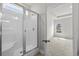 All-white shower with frameless shower door in a modern bathroom at 1208 Nw Calabash Station Blvd., Calabash, NC 28467