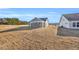 A view of the back of the house and backyard with gray siding and lots of open space at 128 Joyce Dr, Longs, SC 29568