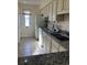 Galley kitchen features granite countertops and white cabinets at 1650 Deer Creek Rd., Surfside Beach, SC 29575