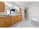 Bathroom with dual sinks, granite countertops, wood cabinetry, and a separate tub and shower at 2113 Clematis Ct., Myrtle Beach, SC 29579