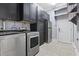 Well-equipped laundry room with black cabinetry, stainless steel appliances, and tile flooring at 2113 Clematis Ct., Myrtle Beach, SC 29579