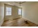 Well-lit bedroom features light-colored walls, wood-look floors, ceiling fan and two windows at 229 South Waccamaw Dr., Garden City Beach, SC 29576