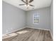 Simple bedroom with light grey walls, ceiling fan, and wood-look flooring at 352 Oak Crest Circle, Longs, SC 29568