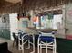 A tiki bar with bar seating, surf decor, and a variety of beverages on display at 4714 Woodland St., North Myrtle Beach, SC 29582