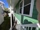 Green two-story exterior of home featuring steps to lower deck and a palm tree at 4714 Woodland St., North Myrtle Beach, SC 29582