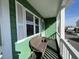 Relaxing porch featuring a green exterior, white railings, and a wicker love seat at 4714 Woodland St., North Myrtle Beach, SC 29582