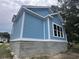 Side view of a blue home with white trim and a gray block foundation, highlighting its construction at 1004 James Island Ave., North Myrtle Beach, SC 29582